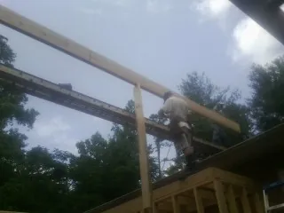 Carpenter setting a ridge beam over a new addition frame — Ice Dam Removal by Roofing Brothers in Donnelsville
