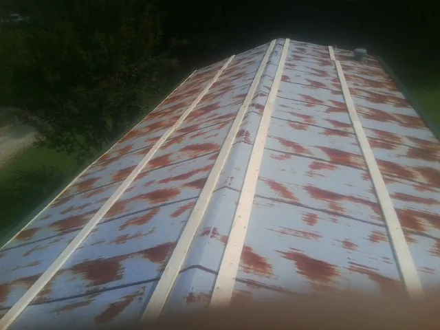 Rusted metal roof panels with new wood purlins before replacement — Storm Damage Roof Repair in Donnelsville by Roofing Brothers