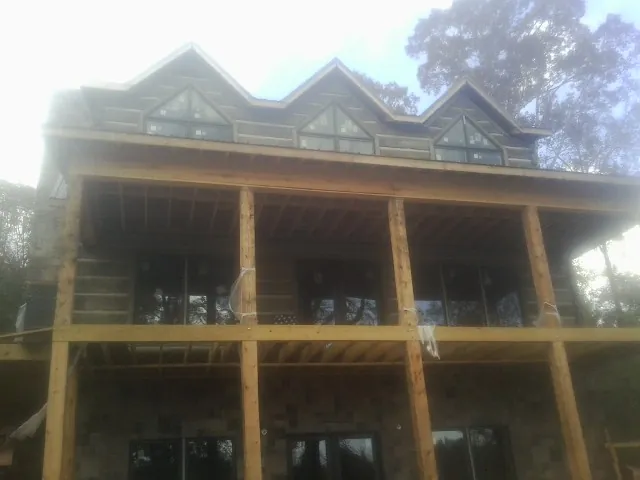 Dormers and porch framing on a large log home under construction — Roof Coating work by our crew in Donnelsville