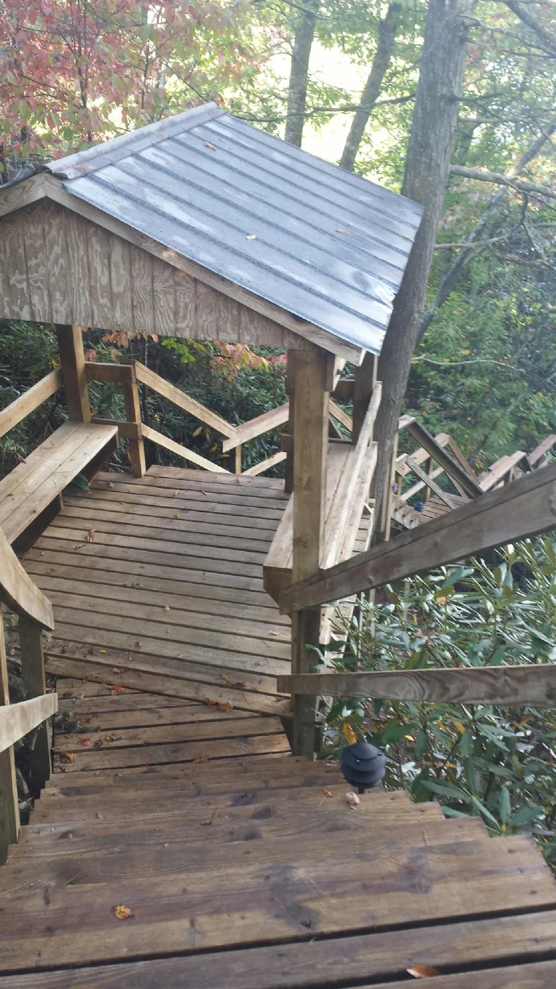 Metal roofed shelter over wooden steps on a wooded walkway — Skylight Repair & Installation work by our crew in Donnelsville