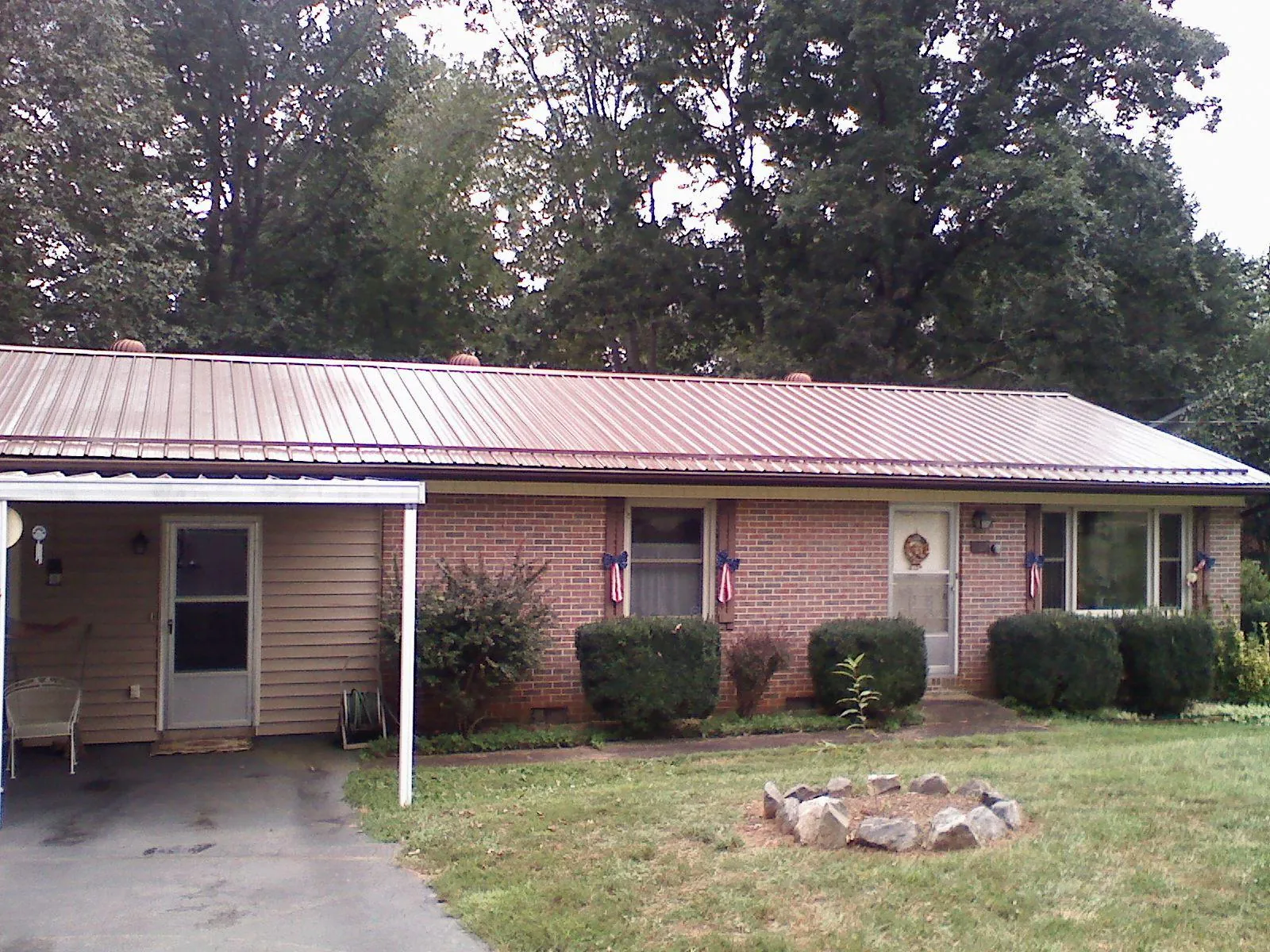 Bronze metal roof and carport on a brick ranch home — Roof Repair work by our crew in Donnelsville