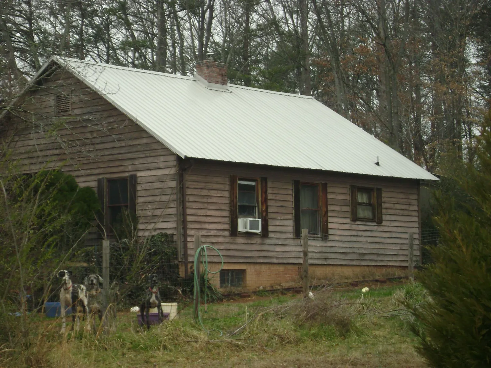 White metal roof on an old wood sided farmhouse, from a Metal Roof Installation job in Donnelsville